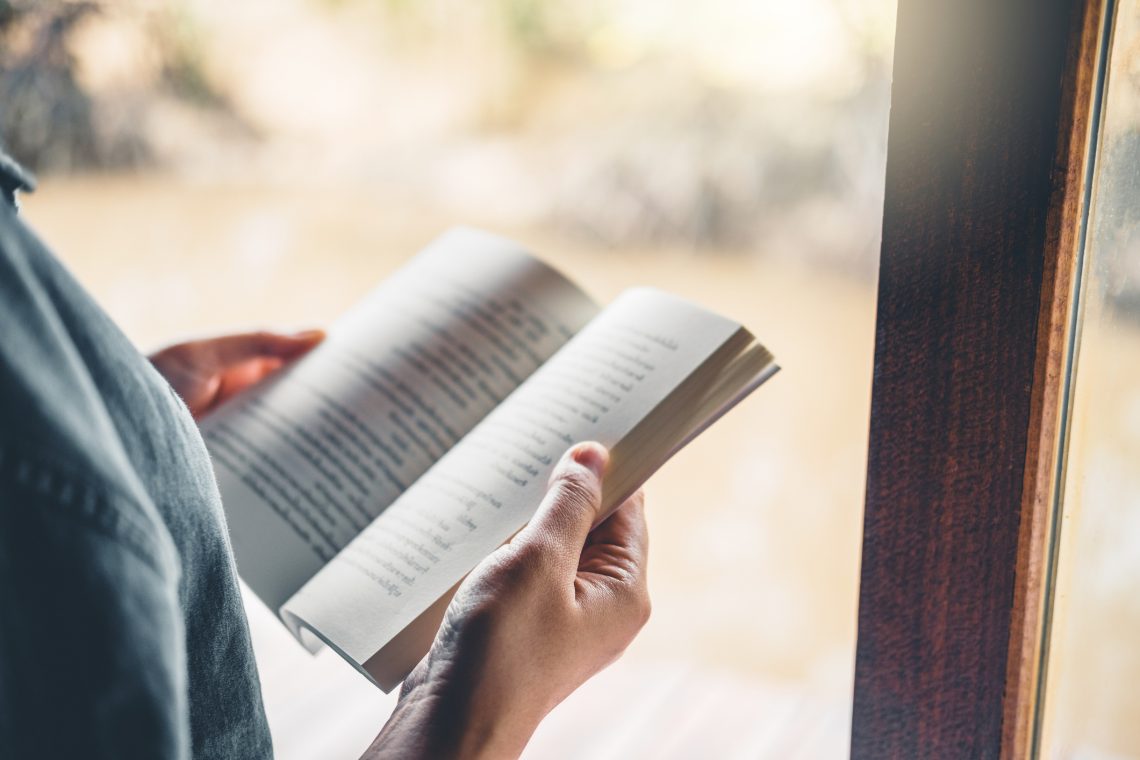 Relaxed woman reading a book on bed in the morning , holiday Time